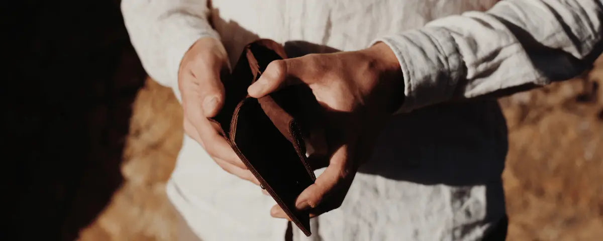 Mains tenant un portefeuille en cuir noir personnalisé, idée cadeau unique pour homme