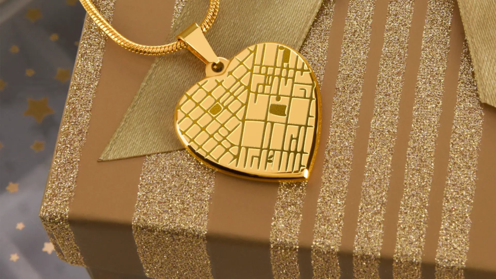 Gold engraved heart pendant necklace resting on gold gift wrap, a sentimental gift