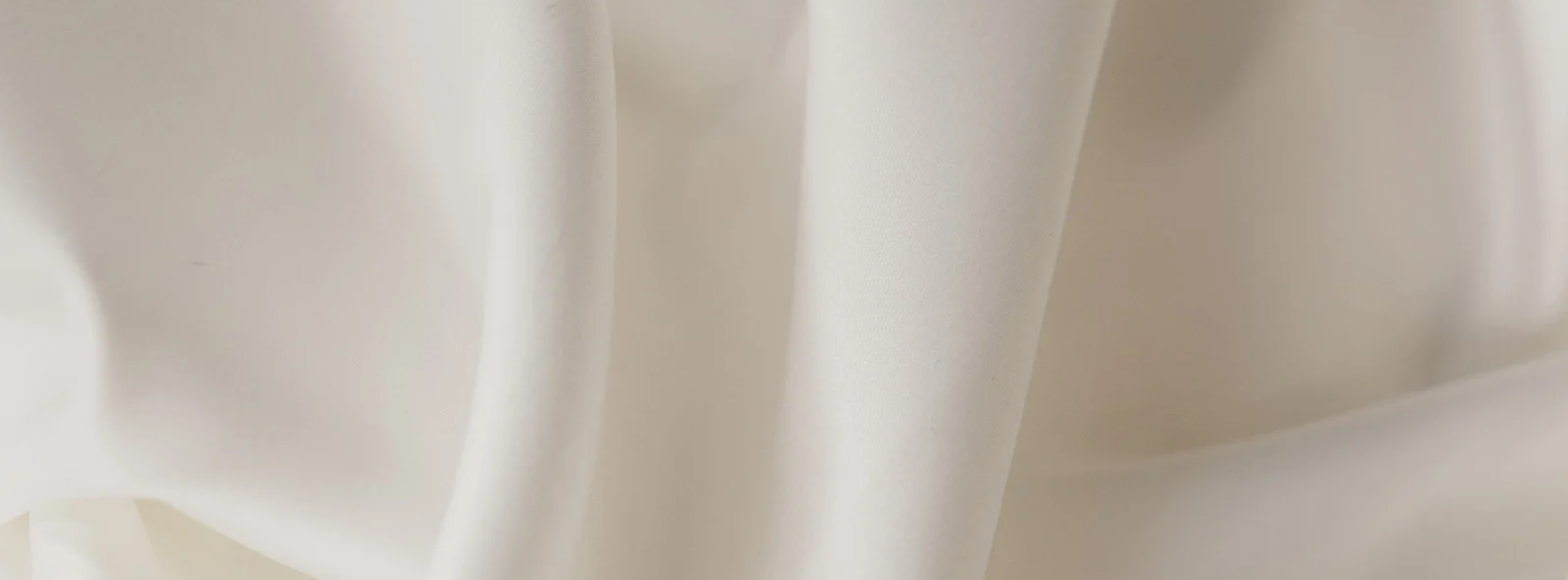 Soft ivory fabric background creating an elegant, warm and premium look for TreasuredTale gifts and jewelry